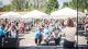 Die Gäste des Netzfests sitzen auf Bierbänken und hören einer Sprecherin zu. Fotografiert von der Bühne aus.
